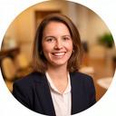 Smiling legal client standing beside a conference table in a warm office