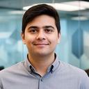 Startup founder standing in a glass meeting room with legal papers and a laptop